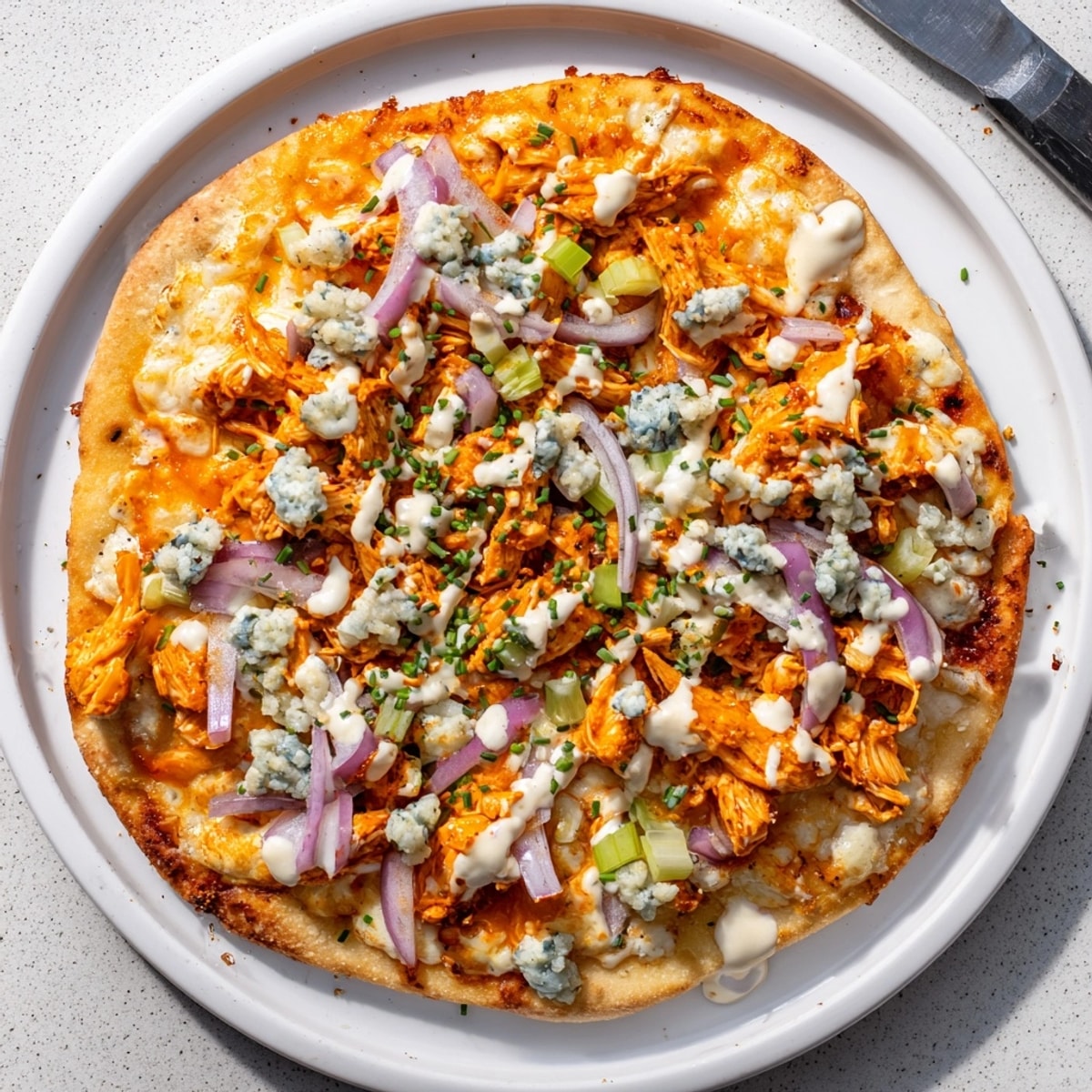 Overhead shot of a bubbling Buffalo Chicken & Blue Cheese Flatbread fresh from the oven.