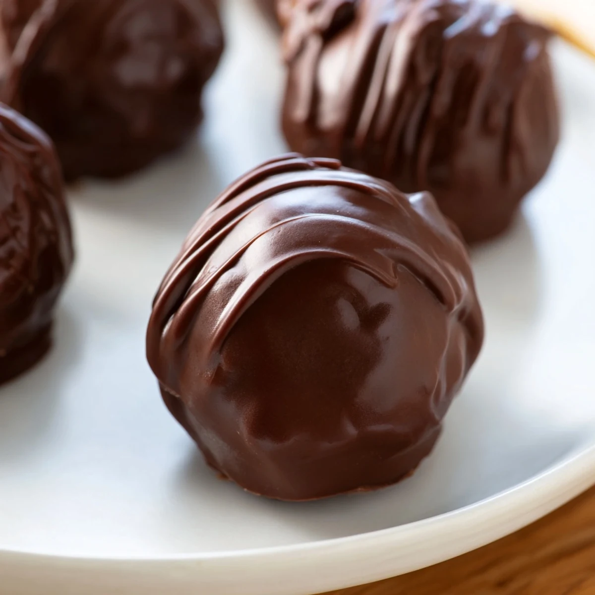 Dark, glossy melted chocolate coats delicious Chocolate Peanut Butter Balls, a classic American no-bake delight.