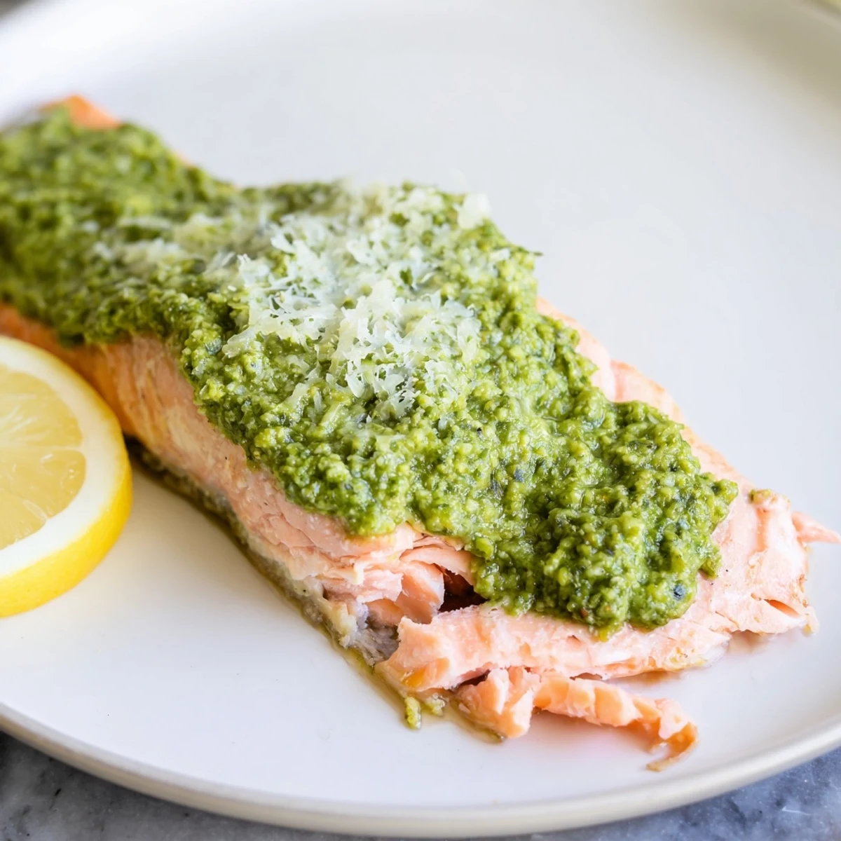 Close-up of baked salmon with pesto showcasing the vibrant colors and tender, cooked texture.