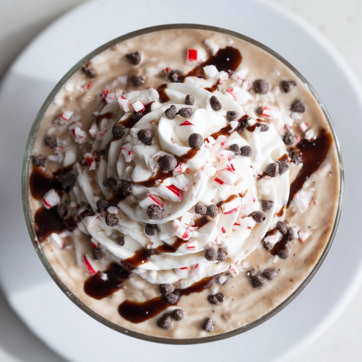Frothy Peppermint Mocha Frozen Blended Coffee topped with whipped cream and crushed peppermint candies.