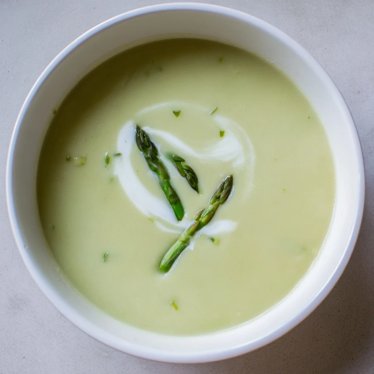 Close-up of a bowl of creamy asparagus soup showcasing the vibrant green color and texture.