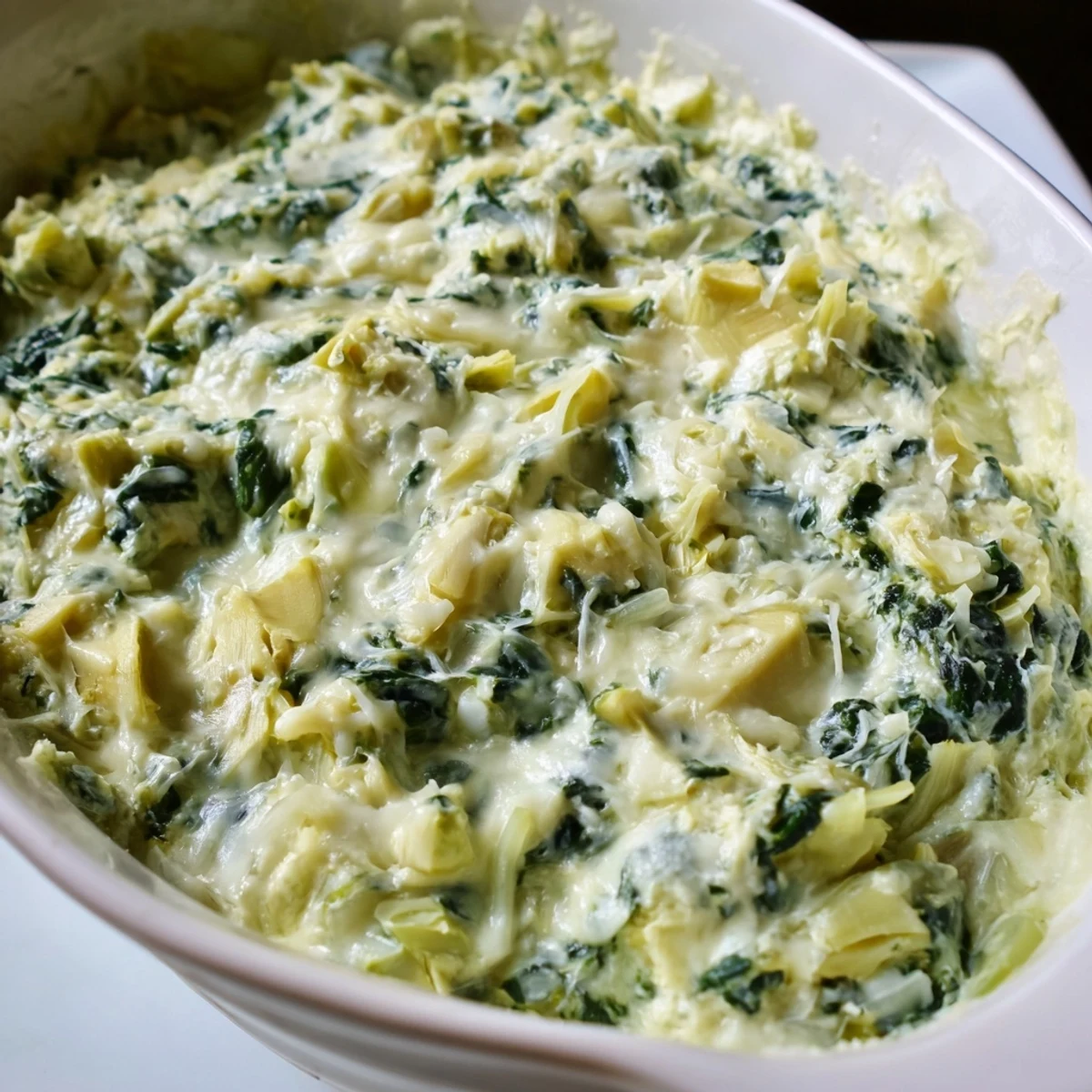 Warm, bubbling Creamy Spinach and Artichoke Dip, perfect with crispy tortilla chips for dipping.