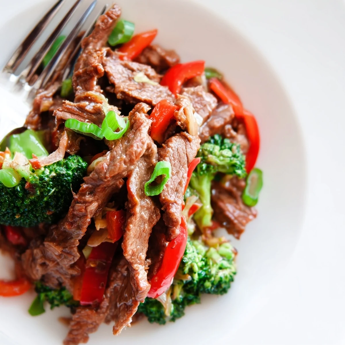 Spicy Beef Stir Fry with Broccoli served family-style, steaming hot next to chopsticks and a cold lager.