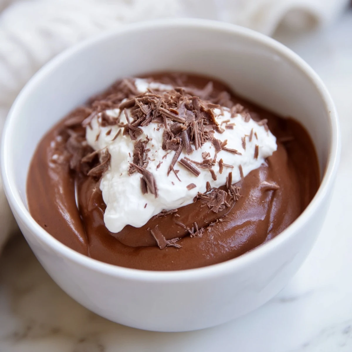 Silky Chocolate Mousse with Homemade Whipped Cream served elegantly in a glass, topped with delicate chocolate shavings.