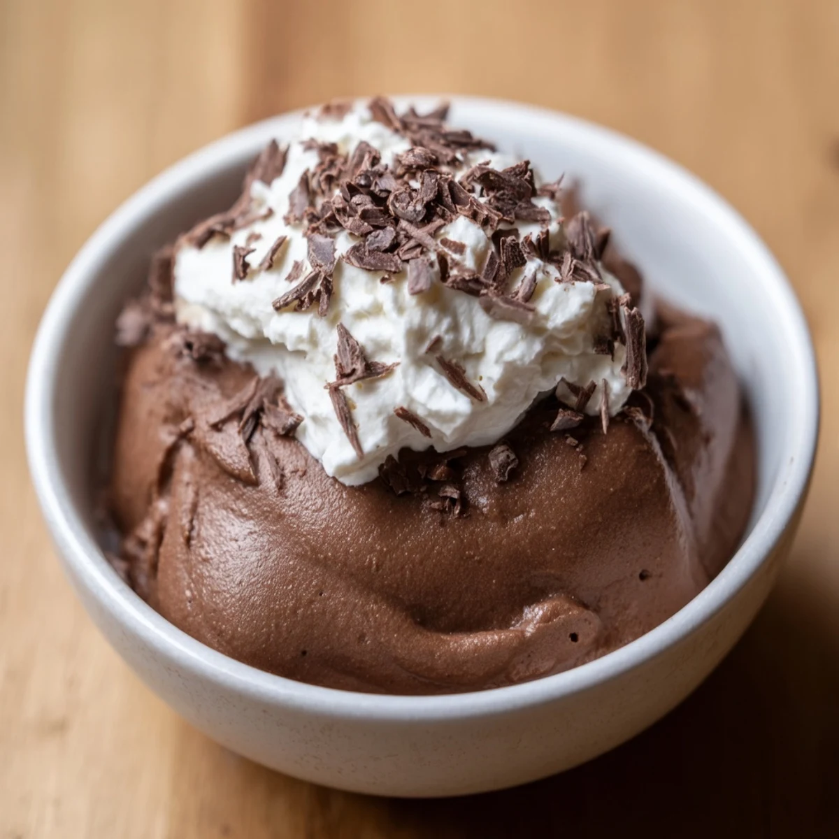 Rich chocolate brown Chocolate Mousse with Homemade Whipped Cream, featuring a fluffy white topping and cocoa dusting.