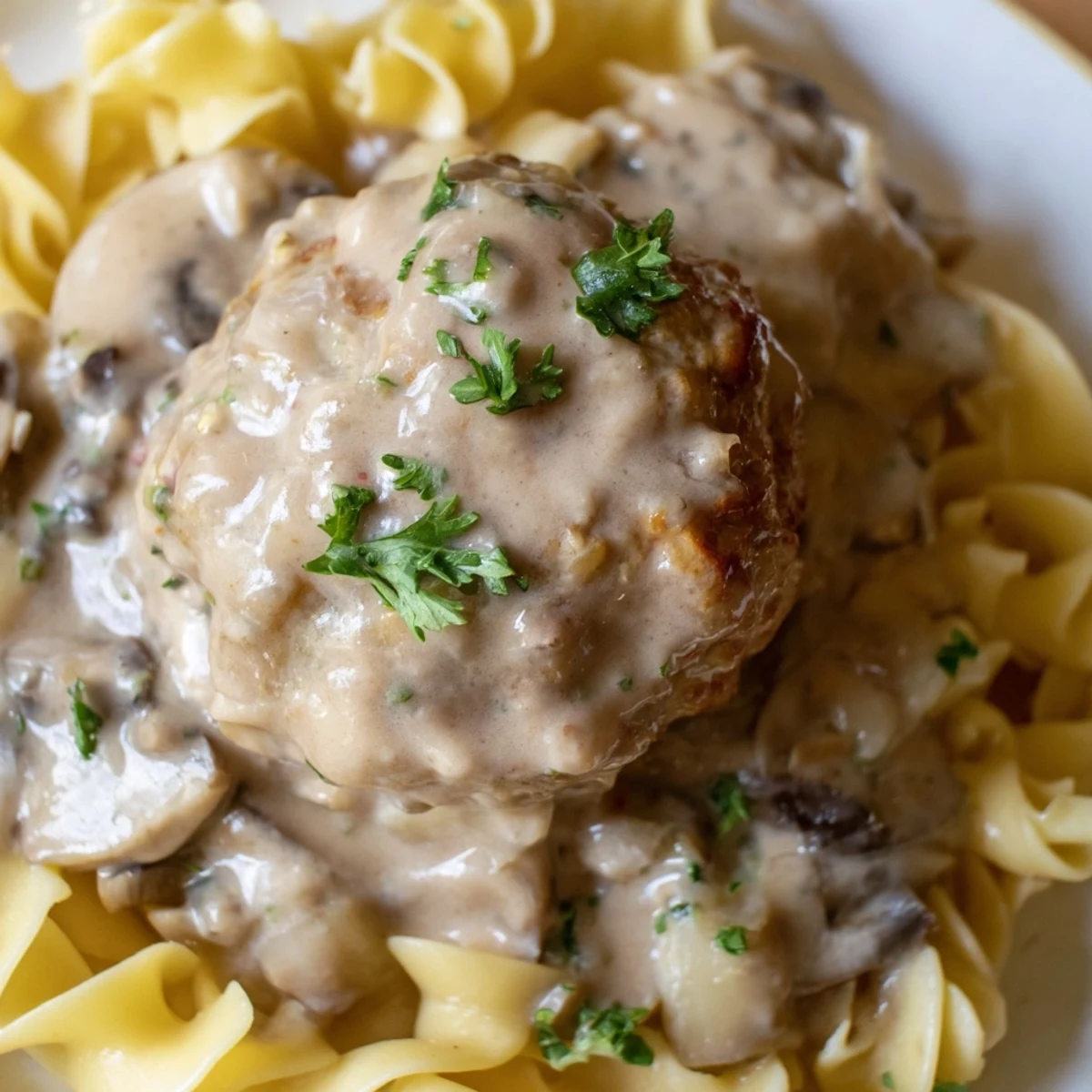 Hearty Turkey Meatball Stroganoff on egg noodles, with parsley garnish and rich sauce ready to serve.