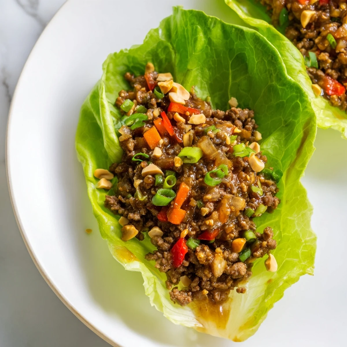 Golden-brown ground beef sautéed with onions, carrots, and garlic, then tossed in a spicy hoisin glaze and served in fresh lettuce wraps.  