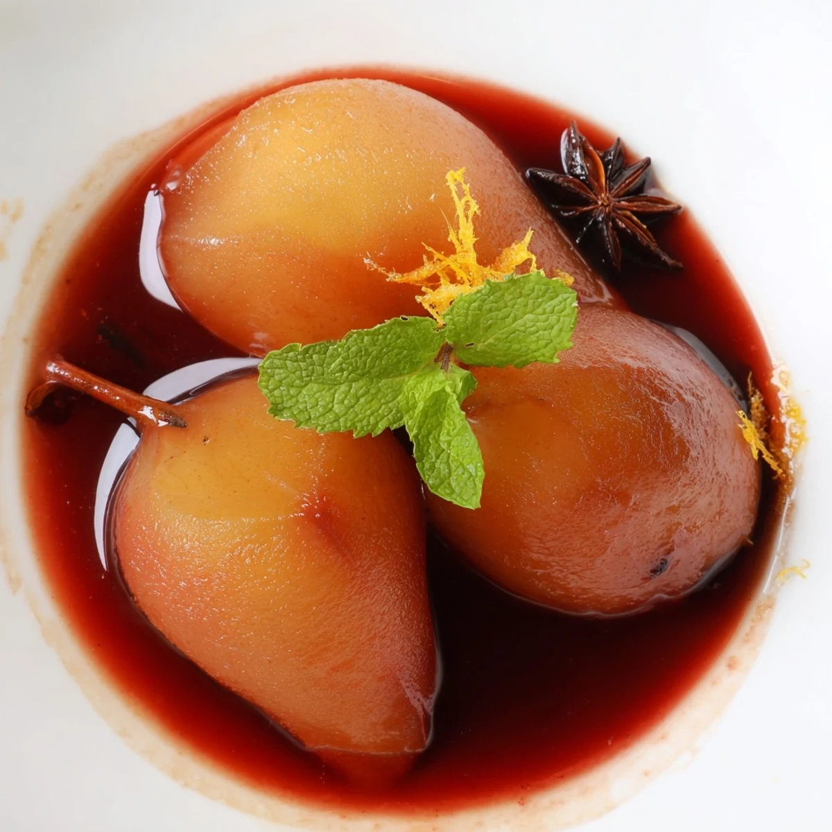 Fresh Romantic Poached Pears in Grape Juice are served with a dollop of whipped cream and mint. 