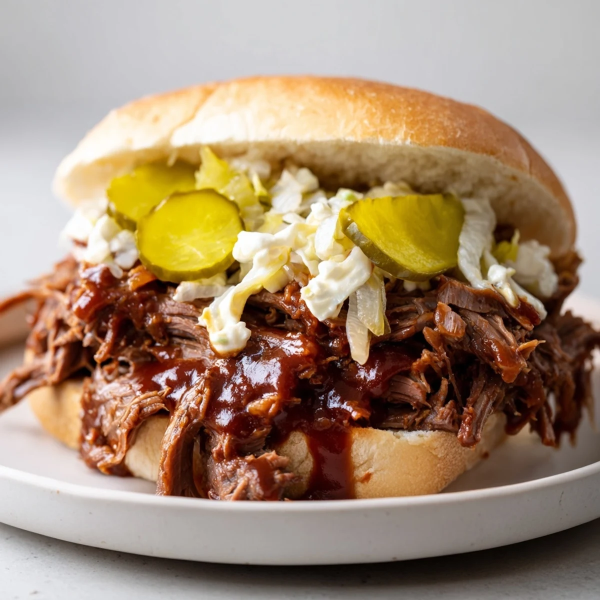 Steam rises from Slow Cooker Pulled Beef Sandwiches as the saucy shredded beef fills the soft buns, ready for a delicious weeknight dinner.