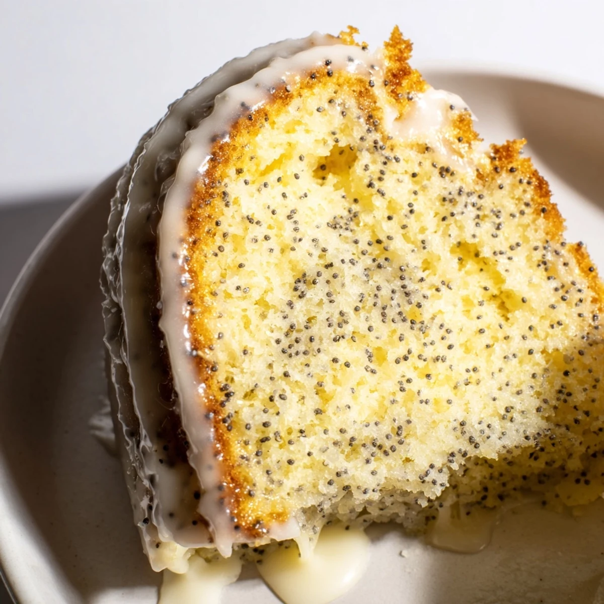 Sliced Lemon Poppy Seed Bundt Cake reveals a tender crumb, ideal for brunch, dessert, or afternoon tea with berries.