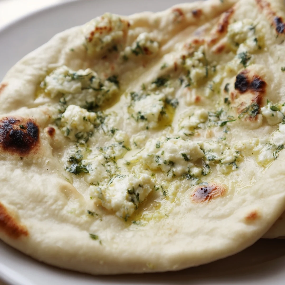 Freshly cooked Cottage Cheese Garlic Naan with bubbly edges, stuffed with soft, creamy cottage cheese.  