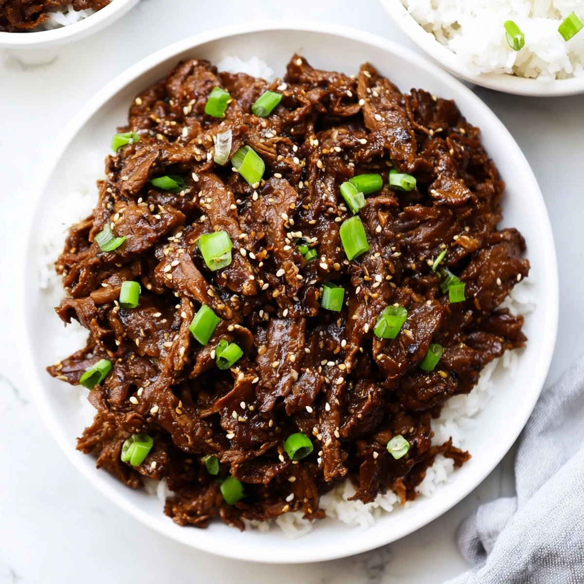 This Slow Cooker Korean Beef is tender, shredded beef with a glossy savory-sweet sauce over steamed rice.