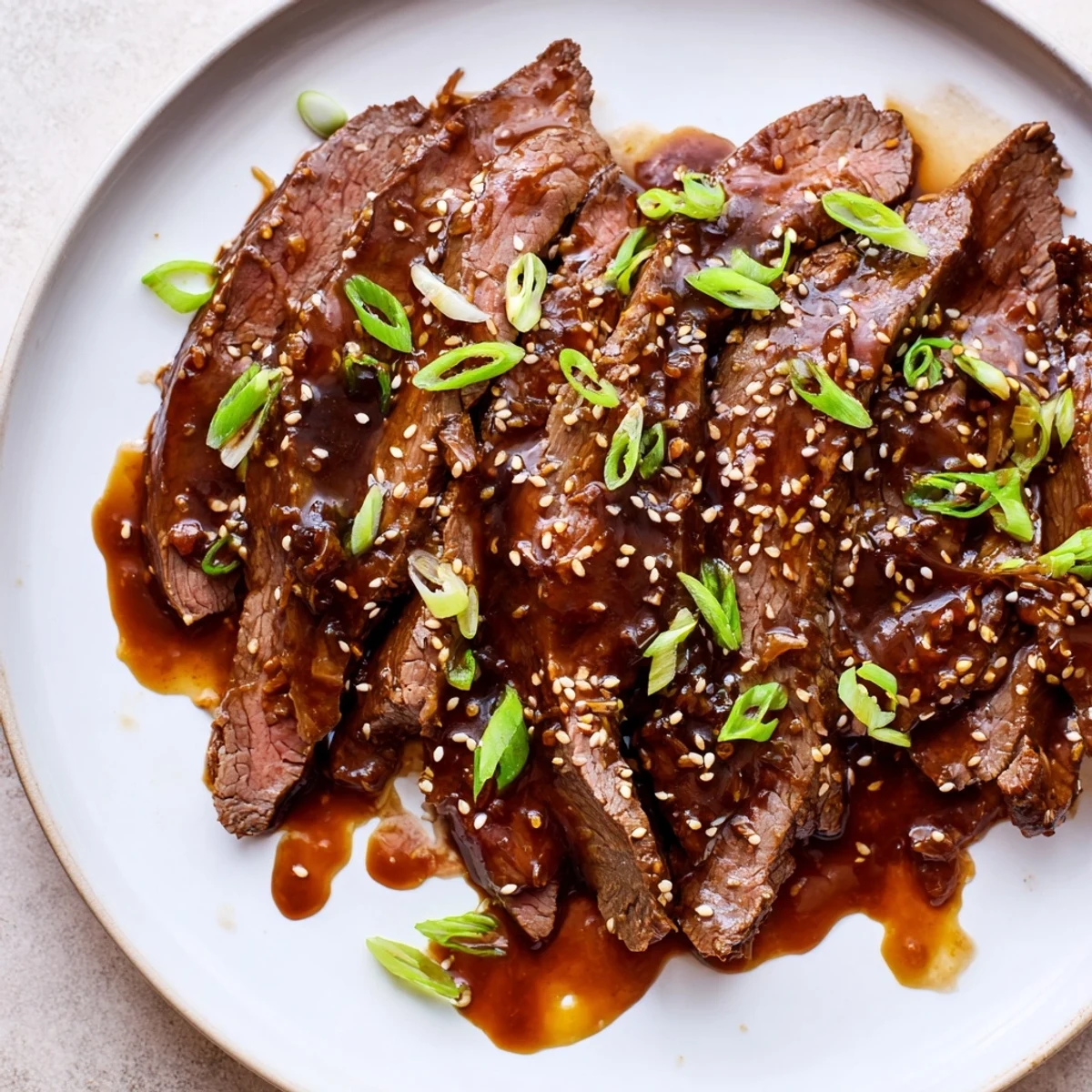 Ultimate Slow Cooker Mongolian Beef simmered until juicy, garnished with sesame seeds over steamed rice.