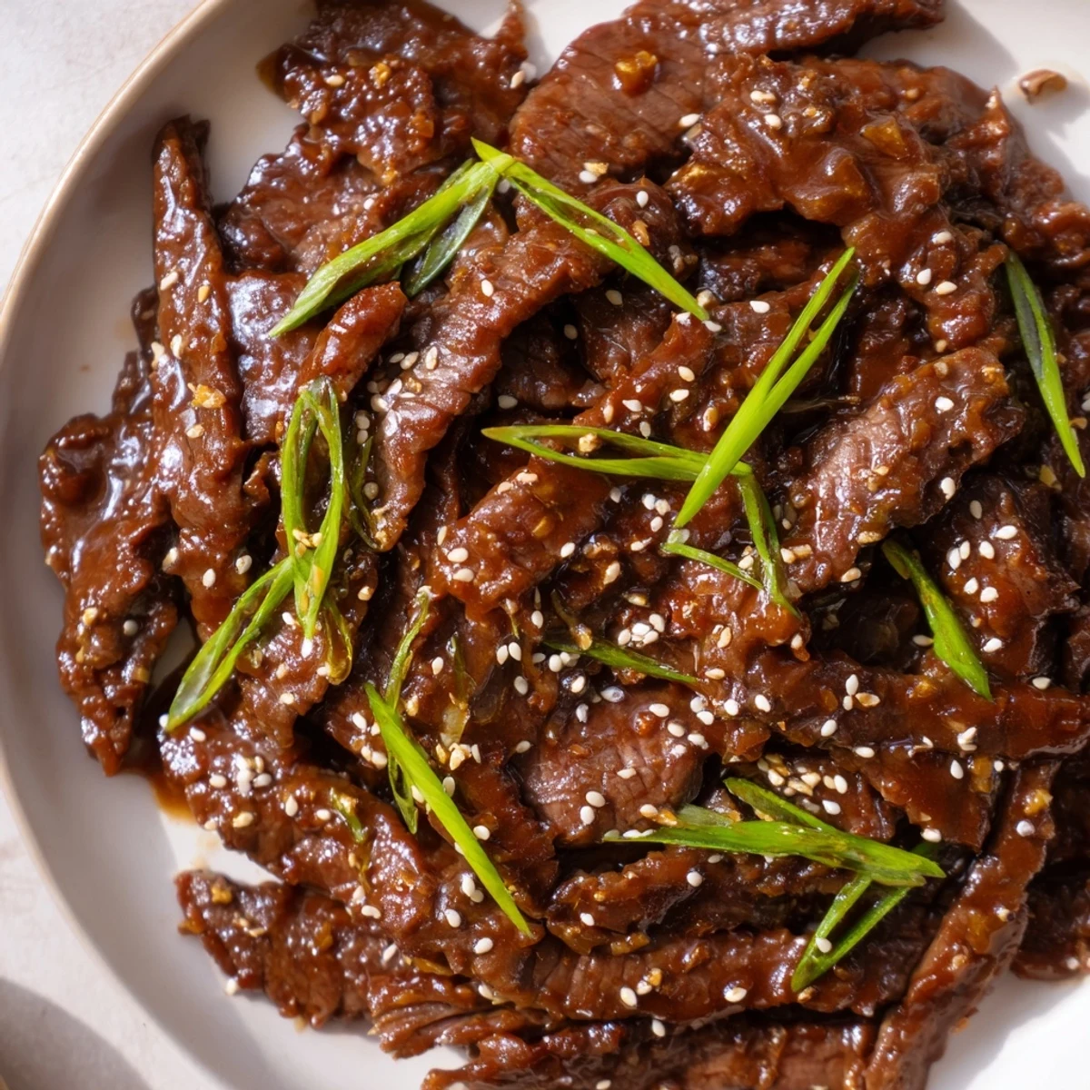 Slow-cooked Ultimate Slow Cooker Mongolian Beef strips glistening in a savory-sweet glaze with garlic and ginger notes.  