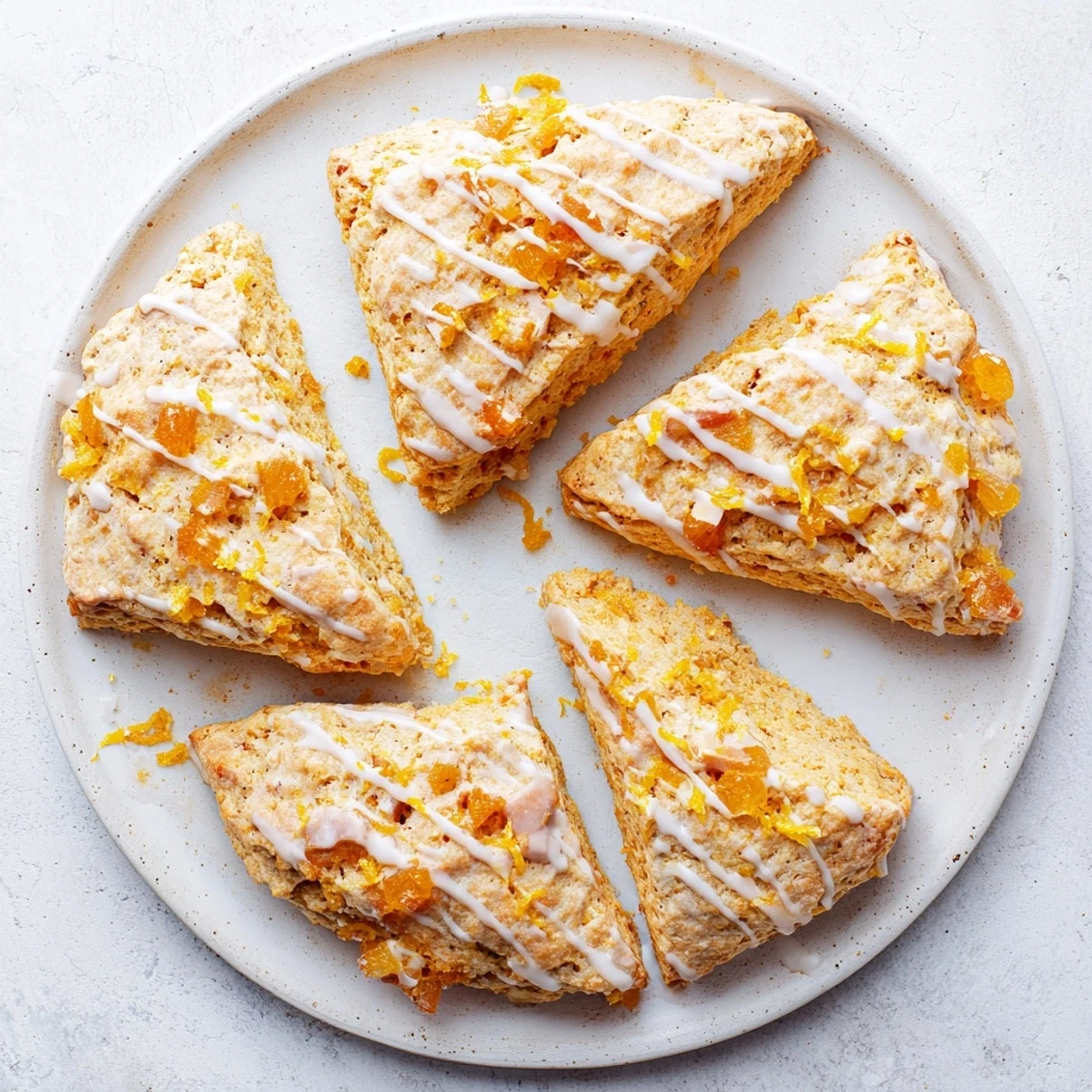 Freshly baked Candied Ginger Orange Scones cooling on a wire rack with a sweet citrus glaze.