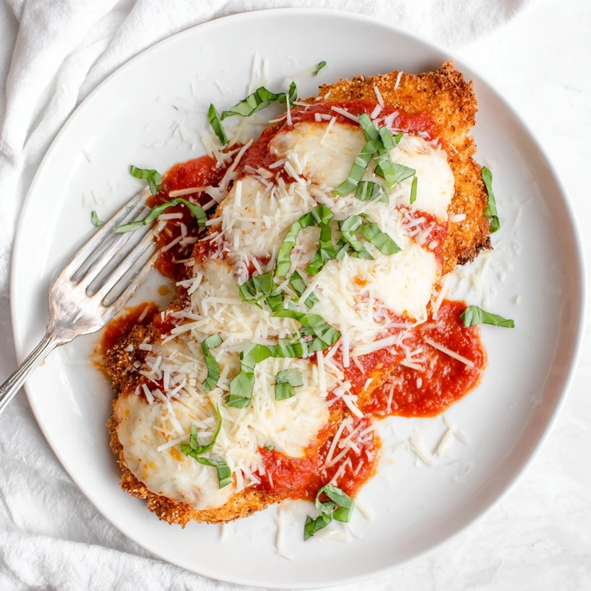 Keto Chicken Parmesan served with zoodles and a green salad for a delicious, healthy Italian meal.