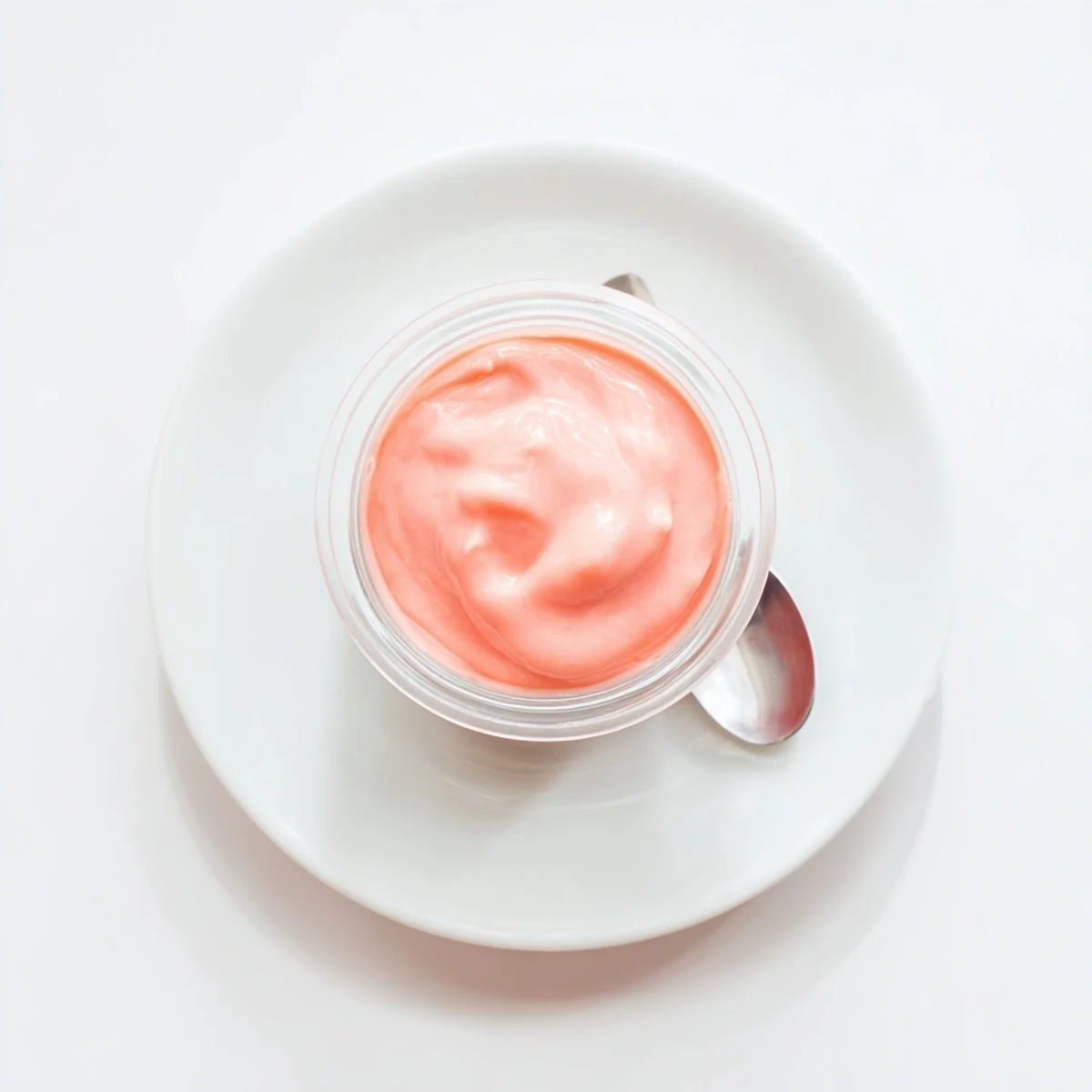 Silky homemade pink lemon curd spread generously on a warm scone with fresh zest