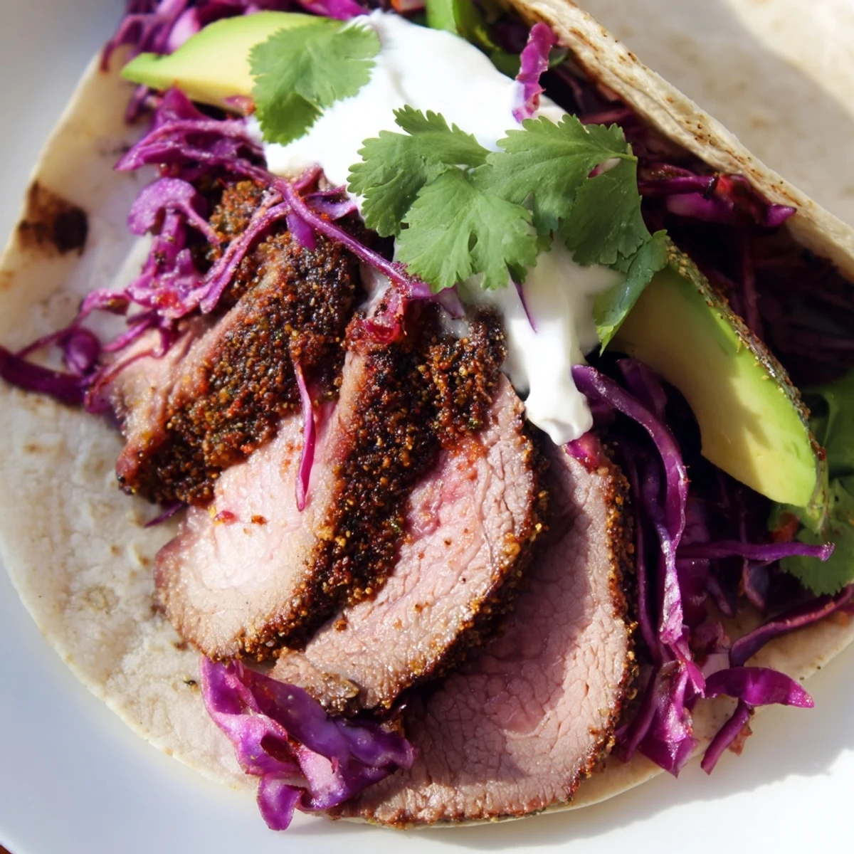 Spiced lamb tacos featuring juicy roasted meat topped with crisp red cabbage and creamy avocado