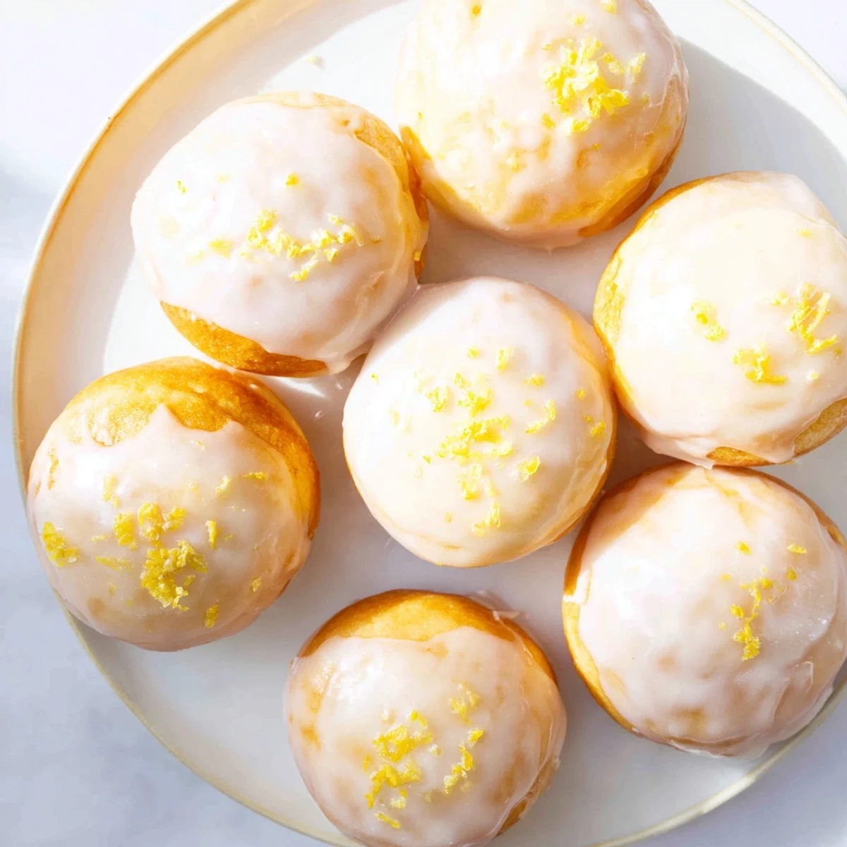 Golden lemon mochi donuts with tangy glaze dripping down chewy gluten-free rings