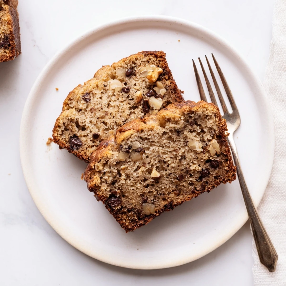 Freshly baked moist banana bread in a loaf pan, dusted with powdered sugar