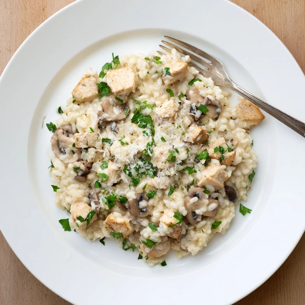 Golden chicken pieces nestled in tender Arborio rice with earthy mushrooms and fragrant herbs