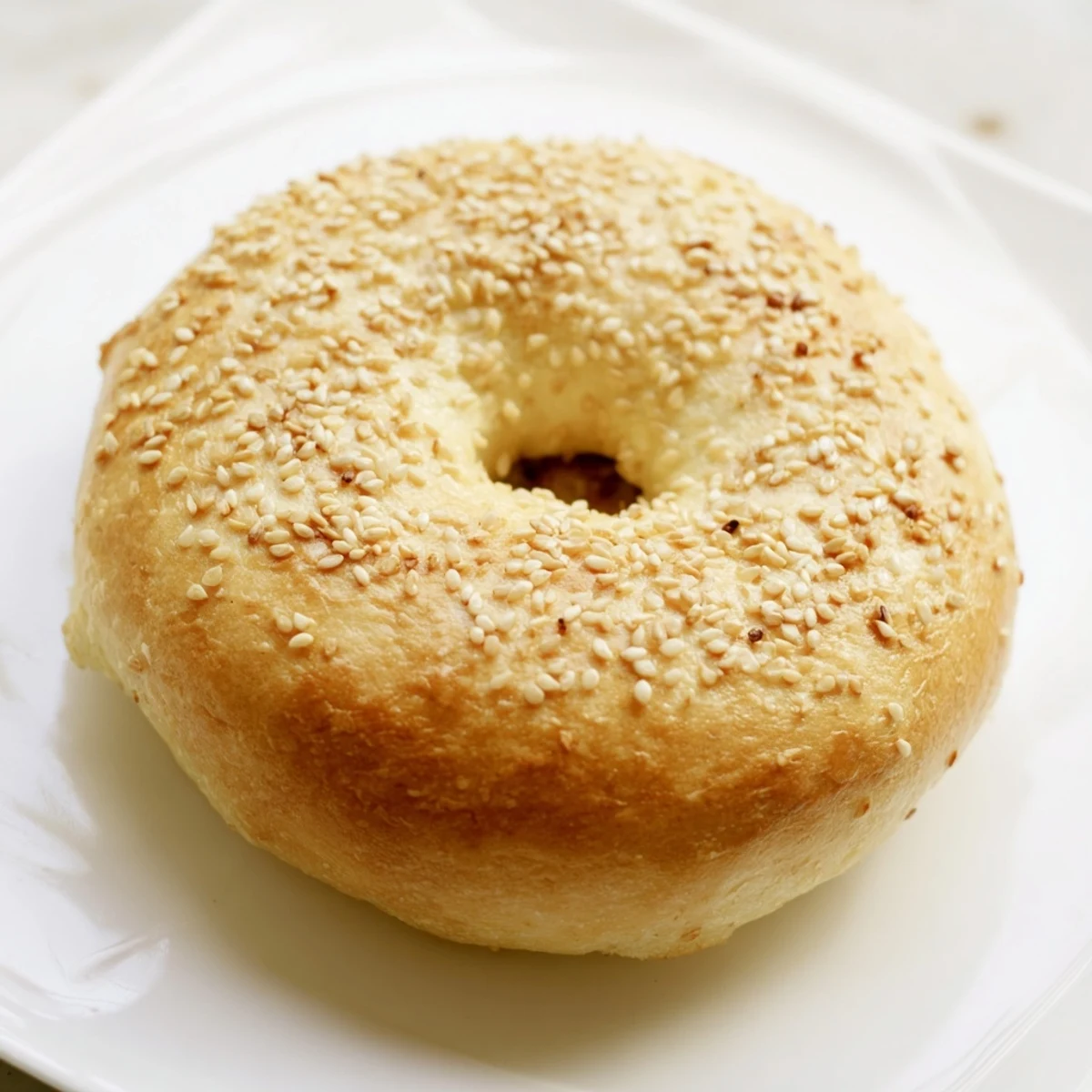 Golden brown spinach cottage cheese flagels sprinkled with sesame seeds on a wire cooling rack