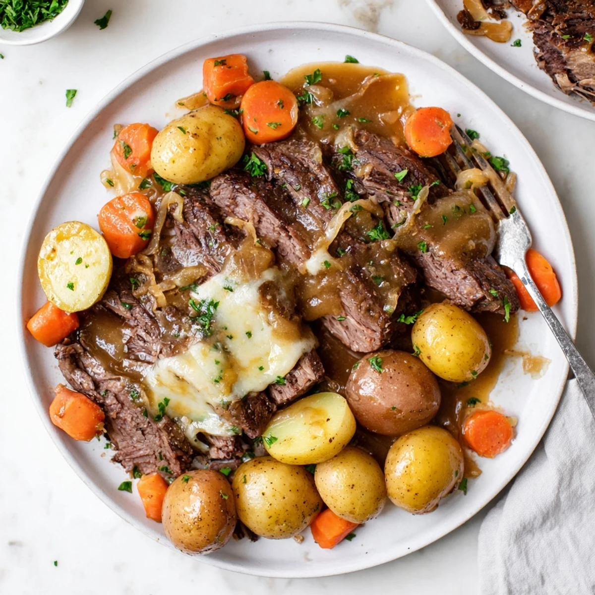 Succulent braised beef chuck roast served alongside golden carrots and melted Gruyère cheese in a savory onion broth