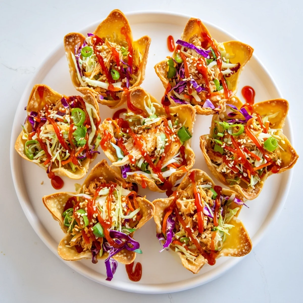 Golden crispy chicken wonton tacos topped with colorful Asian slaw and sweet chili sauce drizzle