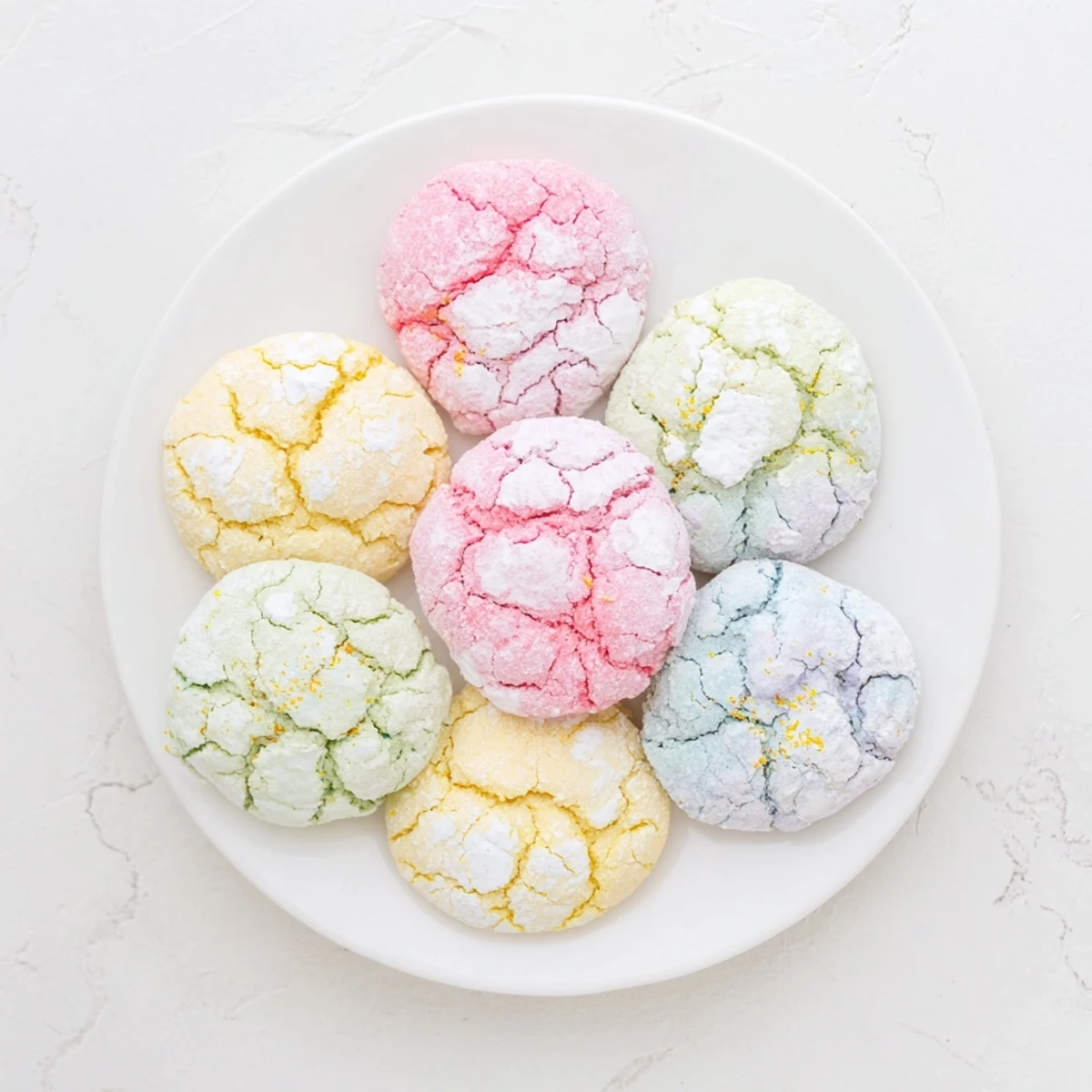 Close-up of soft springtime crinkle cookies showing delicate cracks and pastel hues on cooling rack.