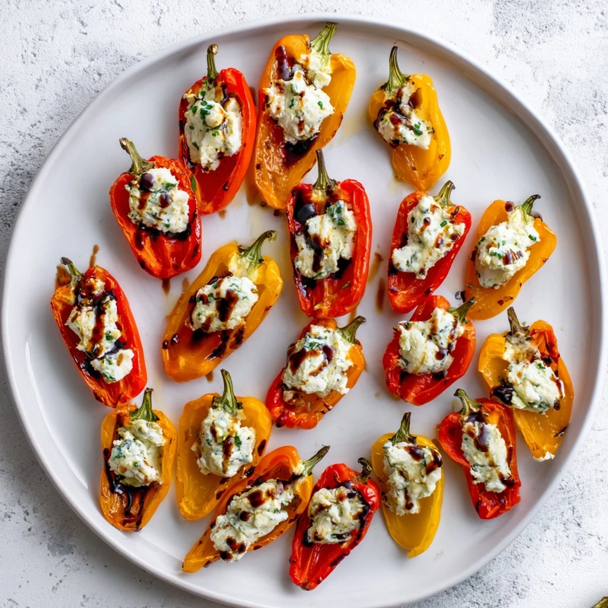 Mediterranean appetizer of blistered mini peppers filled with savory chèvre and garnished with chopped parsley
