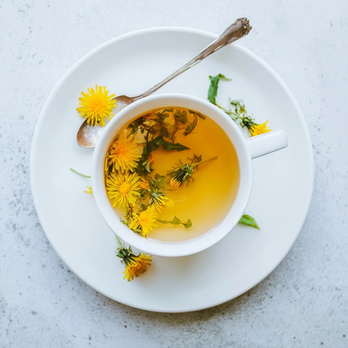 Golden amber dandelion tea steams in a ceramic mug alongside fresh lemon slice