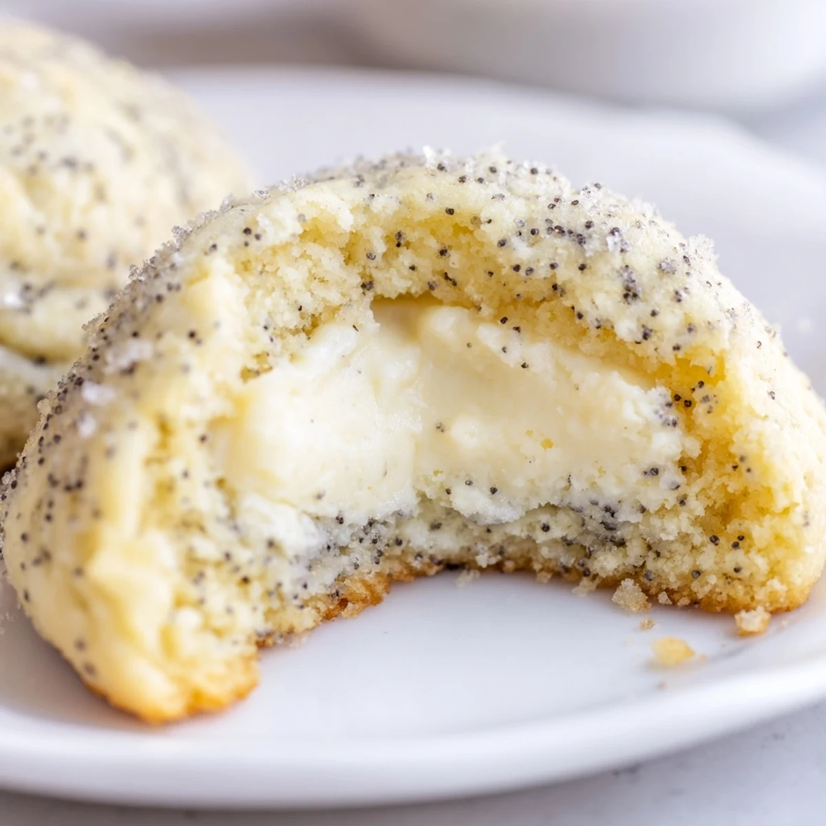 Close-up of crumbled lemon poppy seed cheesecake cookie revealing tangy cream cheese filling