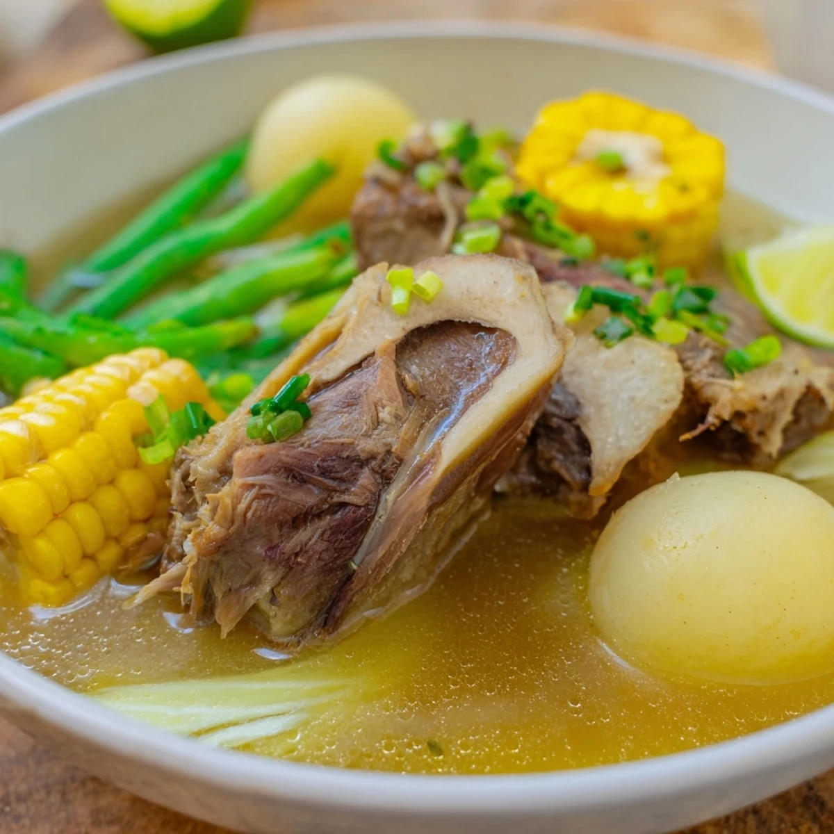 Filipino Bulalo Beef Shank Soup served with corn, cabbage, and a marrow spoon