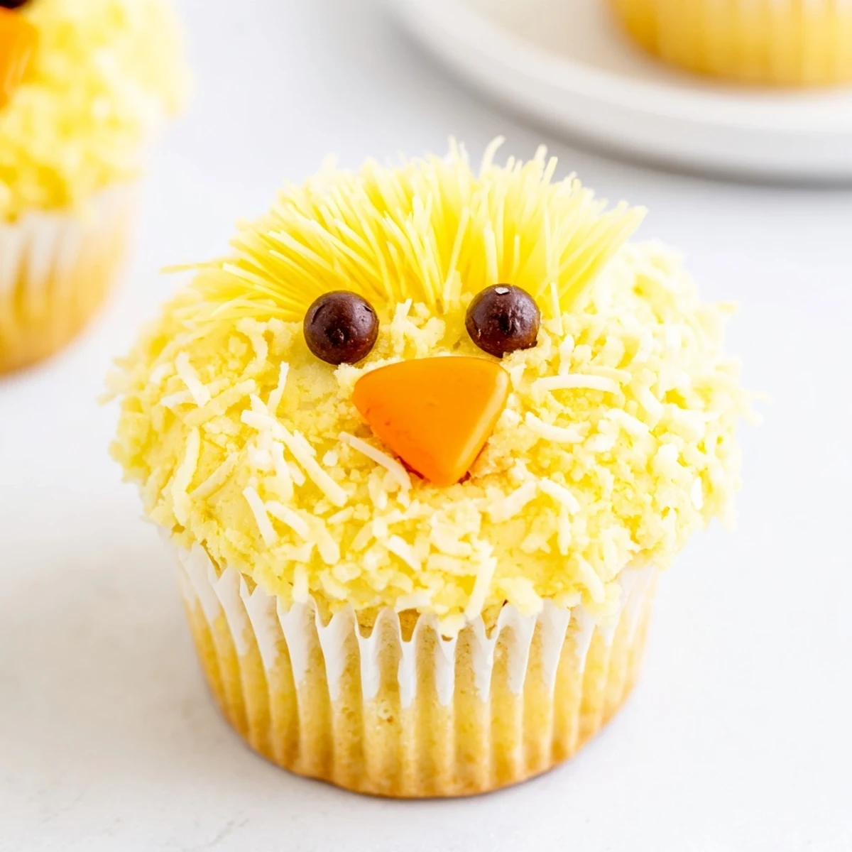 Adorable Easter Chick Cupcakes with fluffy yellow frosting and candy faces on display