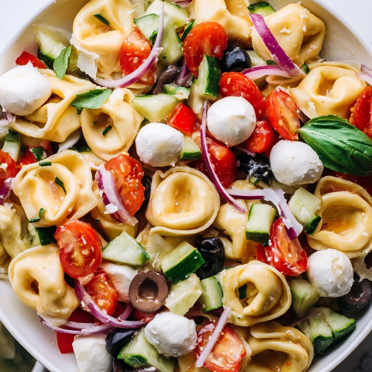 Colorful tortellini salad tossed with crisp vegetables and creamy mozzarella in Italian dressing