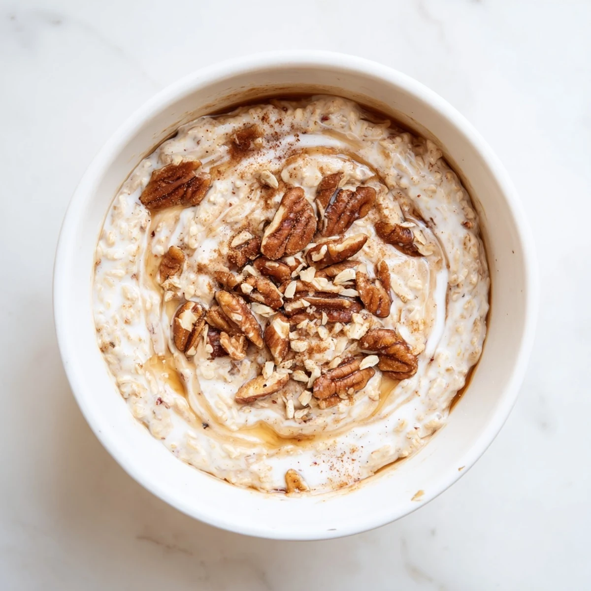 Maple cinnamon pecan overnight oats topped with toasted nuts and a sweet maple drizzle