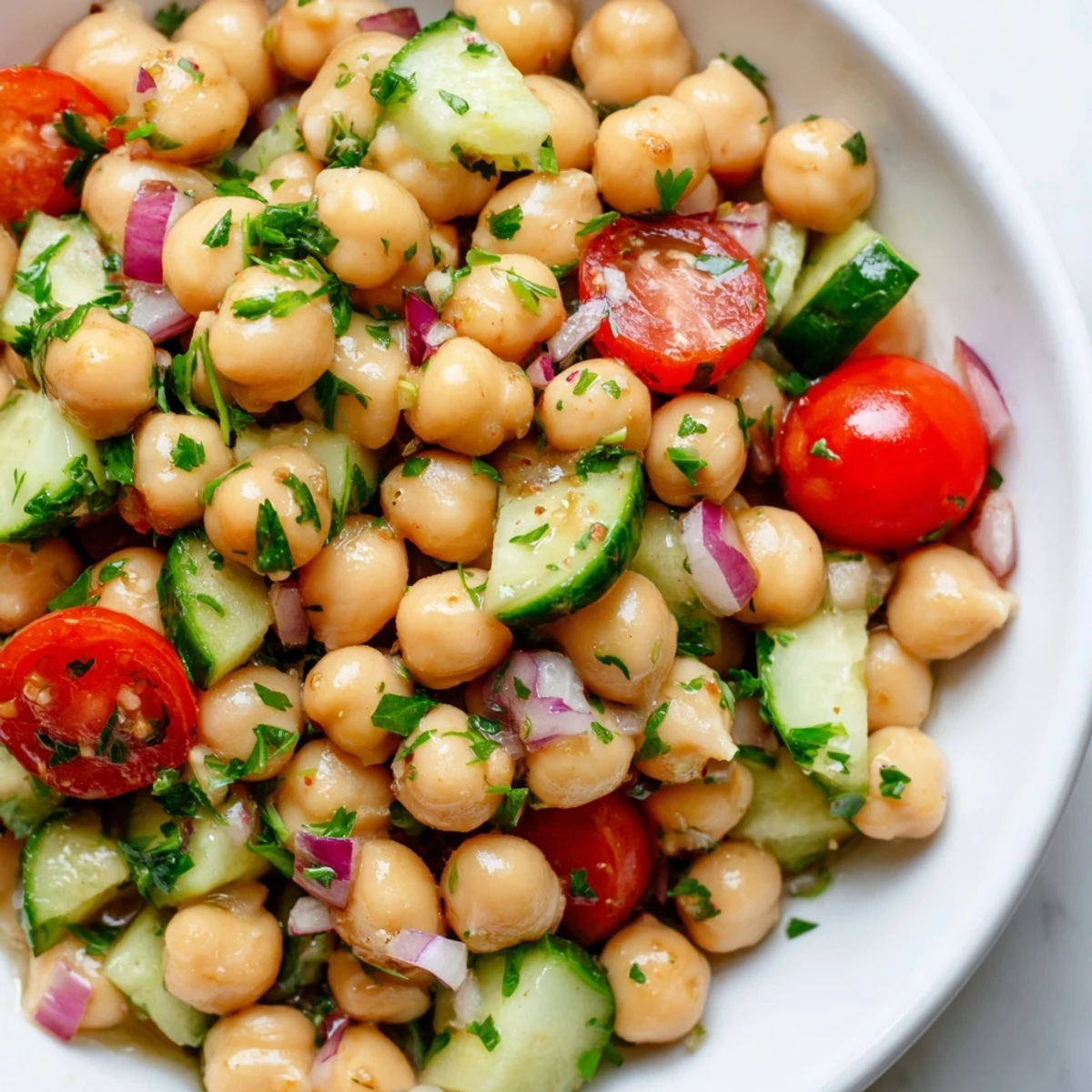 Crispy chickpea cucumber salad drizzled with bright lemon herb dressing on a rustic table