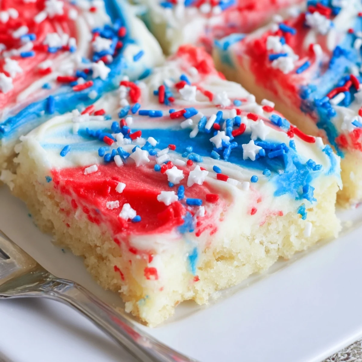 Patriotic Sugar Cookie Bars 4th Of July Dessert Recipe with swirled red, white frosting