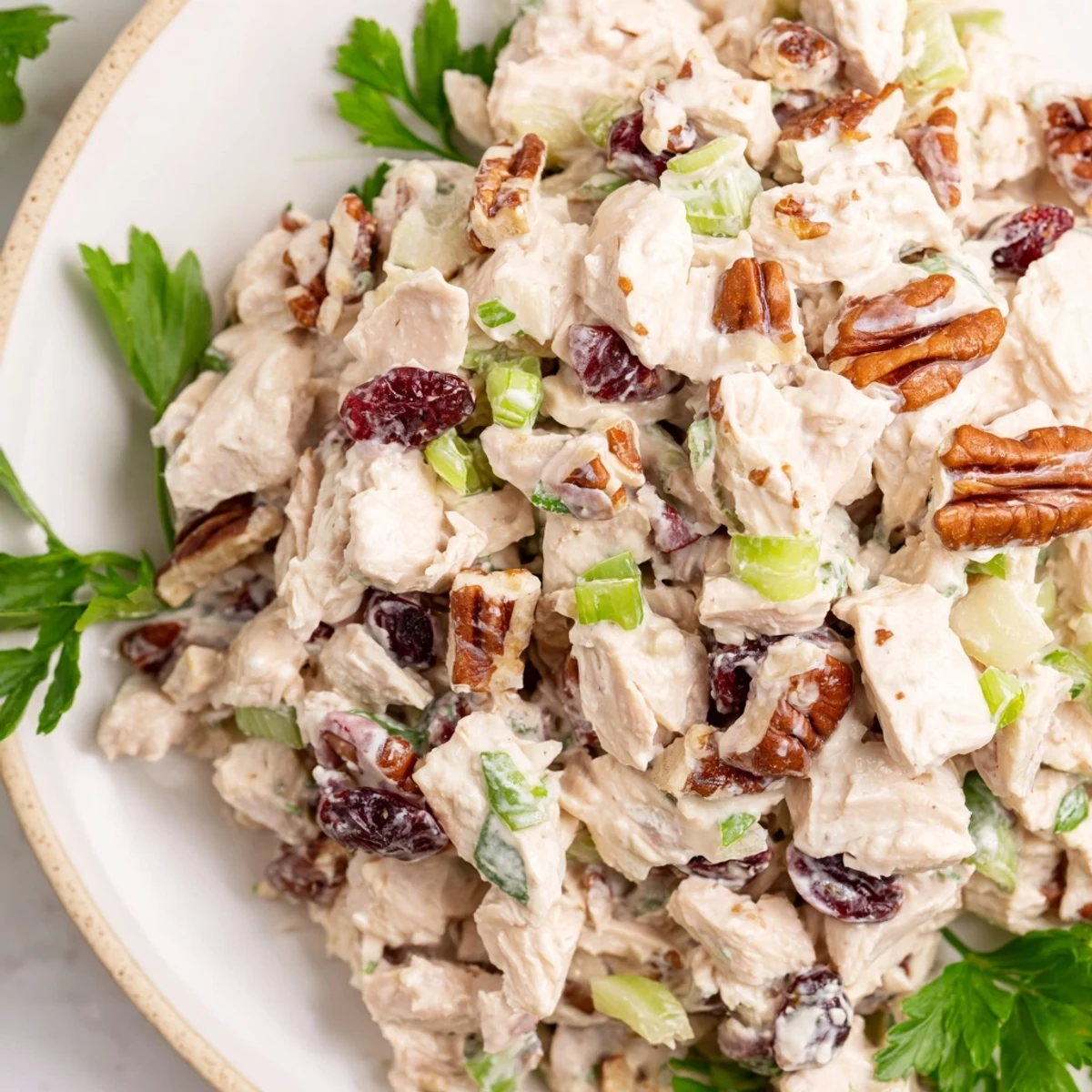 Creamy Cranberry Pecan Chicken Salad served in a white bowl with red cranberries visible