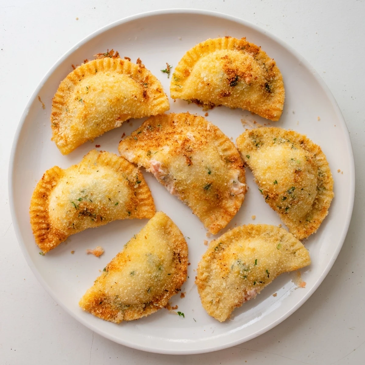 Golden Portuguese shrimp rissois arranged on a white plate with fresh parsley garnish