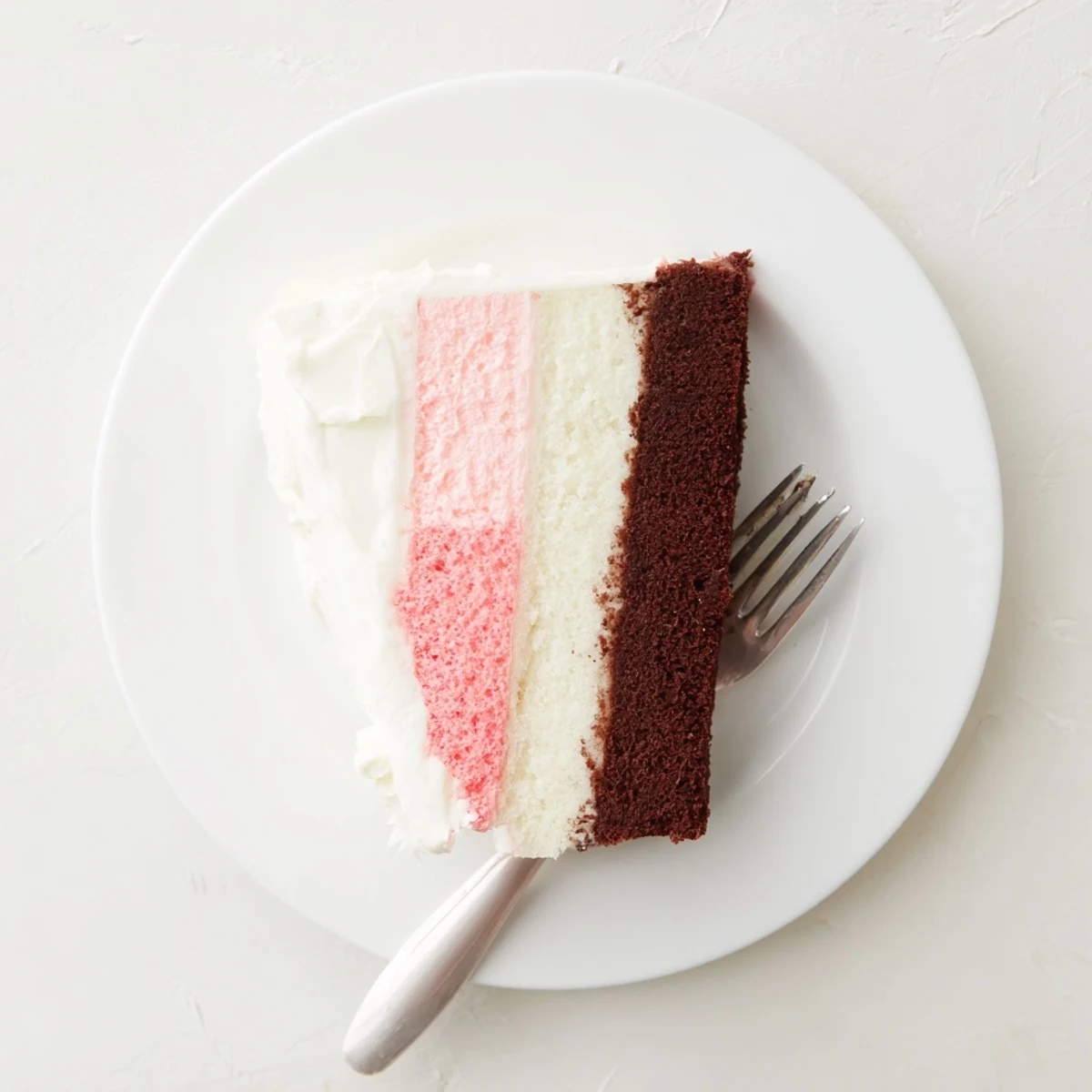 Tri-layer Neapolitan dessert cake showcasing chocolate, strawberry, and vanilla tiers with thick buttercream coating, ideal for birthday celebrations and special occasions