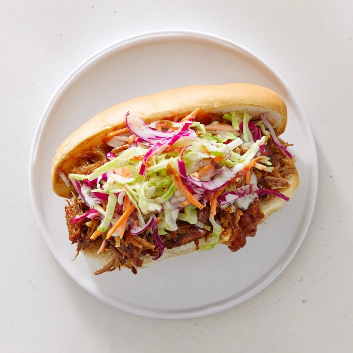 Golden brown smoky BBQ beef sandwiches piled high with vibrant crunchy coleslaw on toasted buns