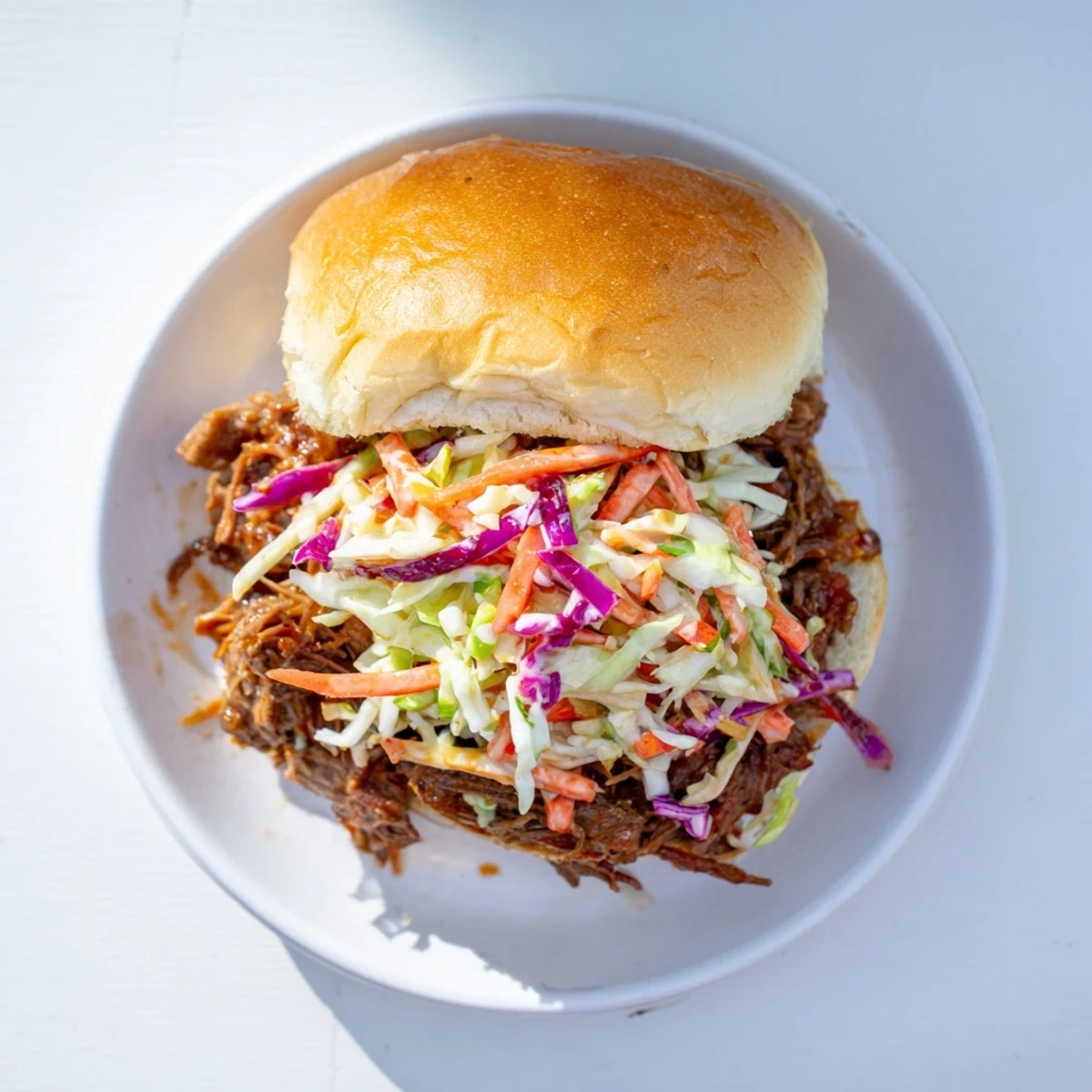 Hearty BBQ beef sandwiches featuring meaty slow-cooked chuck roast balanced with fresh tangy cabbage coleslaw topping
