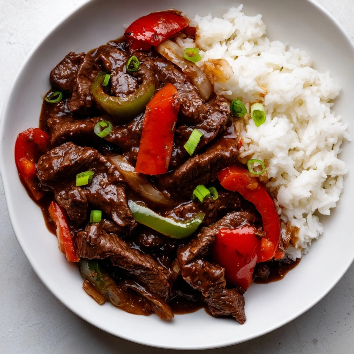 Hearty Slow Cooker Pepper Steak featuring fork-tender beef strips and vibrant red and green peppers