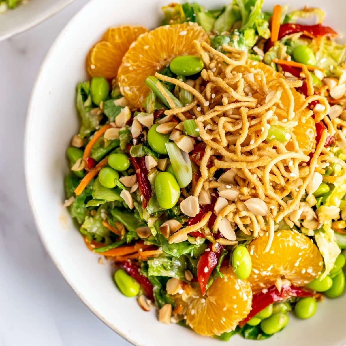 Bright Mandarin Sesame Crunch Salad with glossy orange segments and toasted almonds in a bowl