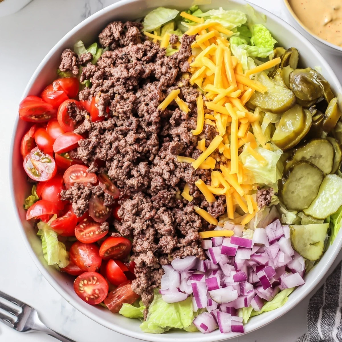 Ultimate burger bowl recipe loaded with savory meat, crunchy toppings, and tangy dressing.