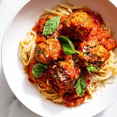 Freshly cooked spaghetti is topped with tender turkey meatballs and a generous ladle of vibrant red marinara sauce for a classic Italian-American dinner.