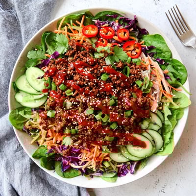 This Satisfy Your Cravings Spicy Keto Korean Ground Beef Salad features hot beef crumbles over crisp greens and red cabbage with a glossy sesame drizzle.